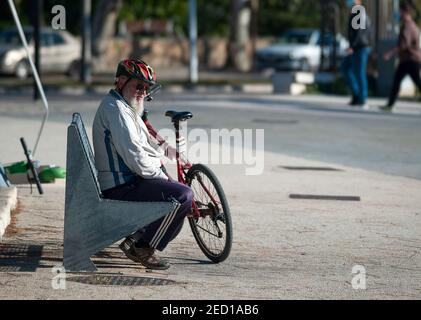 Un ciclista si siede su una panchina durante la protesta. Migliaia di piloti scesi in strada protestando per una pista ciclabile sicura a Malaga, in Spagna. Dopo la decisione del municipio di Malaga di vietare l'uso di biciclette e scooter lungo le passeggiate e i luoghi pedonali e solo in movimento sulle strade, molti ciclisti e diverse organizzazioni hanno richiesto l'implementazione di una vera e propria rete di biciclette nel centro della città. A favore di questa iniziativa sociale sono state raccolte più di 6.000 firme. Foto Stock