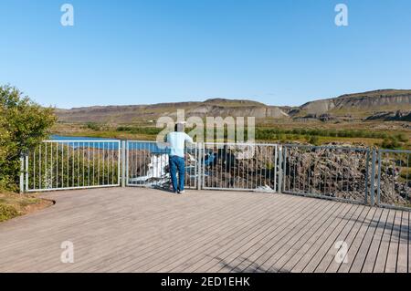 turista godendo la vista dalla piattaforma turistica vicino alle cascate Glanni Nel fiume Nordura a Borgarfjordur in Islanda Foto Stock