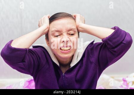 Una donna di mezza età soffre di gravi mal di testa. Foto Stock