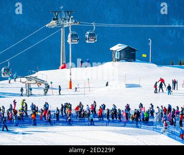 Folle di persone in attesa in fila presso la seggiovia della stazione sciistica alpina di Hafjell. Foto Stock