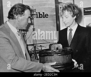 LA STAR POP ROBIN GIBB DEI BEES CON IL PESCATORE ARTHUR MACK CHE TROVÒ IL RELITTO DEL PRIMO HMS INVINCIBILE, AFFONDATO NEL 1758, GUARDA UNA 'SPIT KID' UNA DELLE RELIQUIE SCOPERTE DAI SUBACQUEI DI PORTSMOUTH, HANTS, 1984 Foto Stock