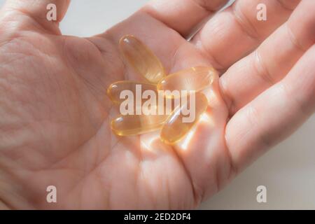 Compresse di olio di pesce nel palmo della mano Foto Stock