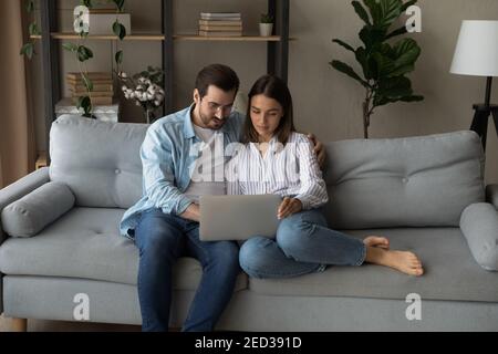Serio giovane coppia che tiene il laptop considerare sulla pianificazione di nozze Foto Stock