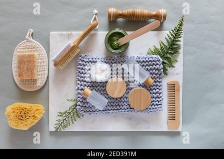 Vista dall'alto di un set completo di cosmetici e accessori per la cura del corpo su una tavola in marmo. Foto Stock