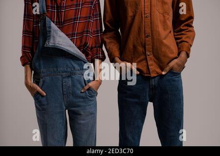 Primo piano foto di stile contadino. Tuta in denim e camicia in plaid Foto Stock