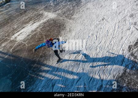Pattinaggio su ghiaccio tra i mulini a vento di Kinderdijk nell'inverno del 2021. Paesi Bassi Foto Stock