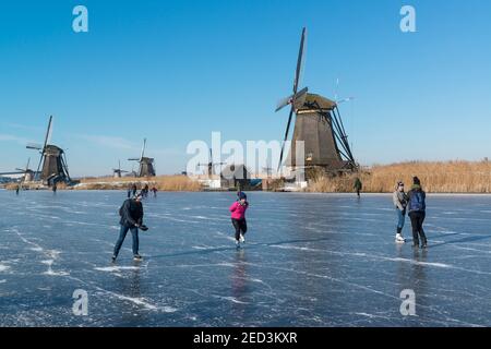 Pattinaggio su ghiaccio tra i mulini a vento di Kinderdijk nell'inverno del 2021. Paesi Bassi Foto Stock