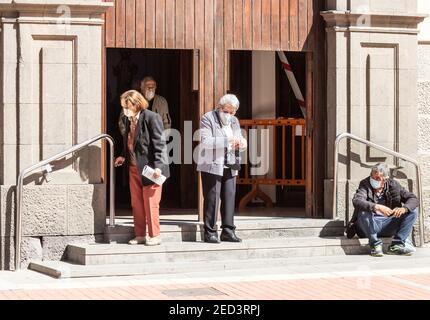 Las Palmas, Gran Canaria, Isole Canarie, Spagna. 14 febbraio 2021. I churchgoers che indossano le maschere di faccia lasciano la chiesa a Las Palmas su Gran Canaria. Credit: Alan Dawson/Alamy Live News. Foto Stock