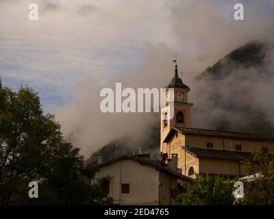 Villaggio chiesa, Entracuqe, Cuneo, Italia con le Alpi Marittime sullo sfondo Foto Stock