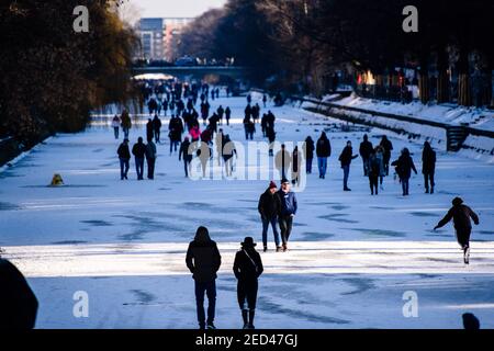 Berlino, Germania. 14 Feb 2021. Germania, Berlino, 14 febbraio 2021: Il giorno di San Valentino, la gente si gode il fine settimana al sole sul canale ghiacciato Landwehr nel quartiere berlinese di Kreuzberg, nonostante le severe restrizioni di contatto e le misure Corona in vigore a causa della pandemia globale del Covid-19 e di un chiaro avvertimento da parte delle autorità berlinesi contro l'ingresso nelle acque ghiacciate. Un fenomeno meteorologico chiamato scissione polare del vortice ha portato neve e venti ghiacciati a Berlino e Brandeburgo con temperature ben al di sotto del congelamento. (Foto di Jan Scheunert/Sipa USA) Credit: Sipa USA/Alamy Live News Foto Stock