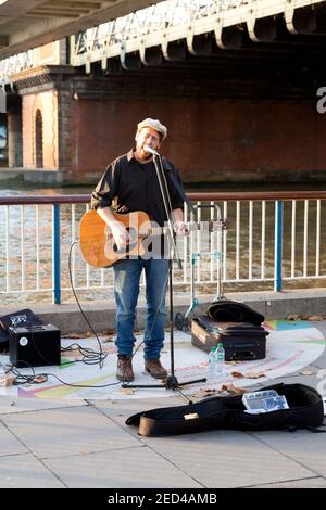 Performer di strada sul lungofiume sotto Hungerford Bridge Foto Stock