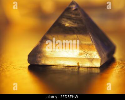 Piramide in cristallo al quarzo trasparente con retroilluminazione e luce calda morbida Foto Stock