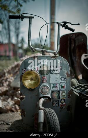 Vespa Vintage abbandonata e rotta nel cortile dell'officina Foto Stock