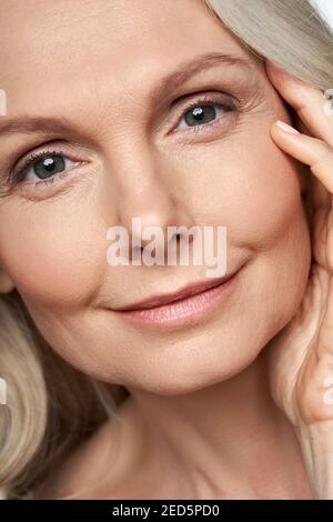 donna di 50 anni che guarda la macchina fotografica. Cura della pelle anti-età. Vista ravvicinata con il lato anteriore Foto Stock