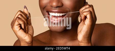 Giovane donna nera con filo interdentale, closeup Foto Stock