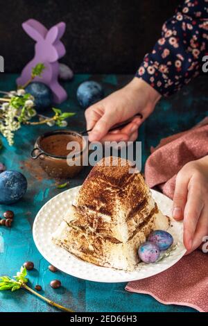 Sfondo di Pasqua. Dessert tiramisù Pasqua casetta formaggio pascha su tavolo di festa. Foto Stock