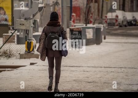 Praga, Repubblica Ceca. 02-13-2021. La donna che attraversa le ferrovie cammina nel centro di Praga durante una fredda giornata invernale. Foto Stock