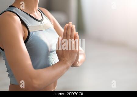 Corpata di donna sportiva che tiene le mani in gesto namaste Foto Stock