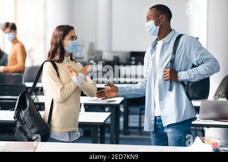 La donna rifiuta il contatto, mostrando il gesto del segnale di stop per la stretta di mano Foto Stock