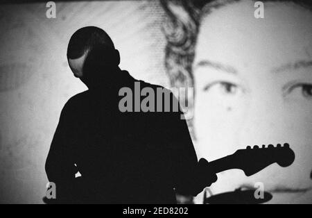 Malcolm Eden del gruppo indie pop McCarthy che si esibisce di fronte ad un ritratto della Regina al Bowen West Theatre di Bedford, 3 marzo 1990. Foto Stock