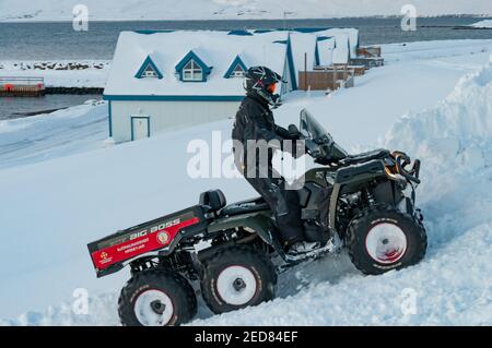 Hrisey Islanda - Dicembre 29. 2017: Membro dell'Associazione islandese di ricerca e salvataggio che guida un ATV nella neve durante l'inverno Foto Stock