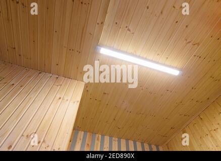 Vista di un soffitto da una fodera in legno con un Lampada LED per luce diurna inclusa Foto Stock