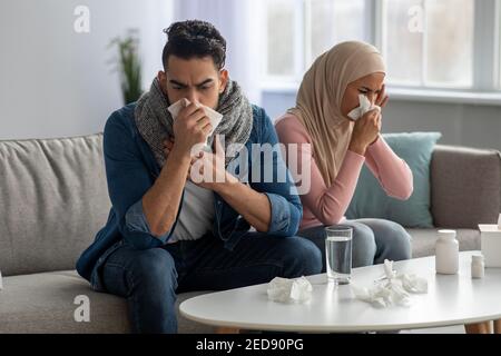 La coppia musulmana starnutisce il naso, soffre di mal di testa Foto Stock