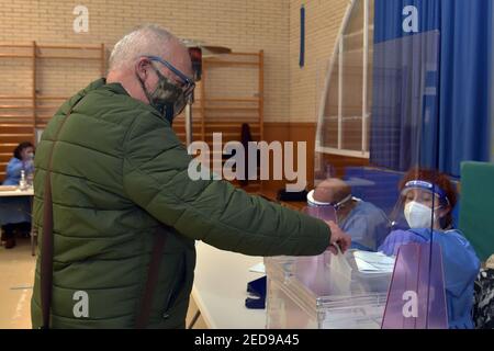 Un uomo che indossa un facemask lancia il suo voto elettorale nelle urne durante le elezioni regionali catalane. Oggi la Catalogna si reca alle urne per votare per il presidente del governo della Catalogna in base a severe misure di sicurezza sanitaria a causa della crisi della pandemia del Covid-19. Ai pazienti positivi al Covid19 viene data la concessione di voti tra le 19:00 e le 20:00 Foto Stock