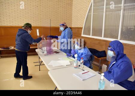 Un uomo che indossa un facemask lancia il suo voto elettorale nelle urne durante le elezioni regionali catalane. Oggi la Catalogna si reca alle urne per votare per il presidente del governo della Catalogna in base a severe misure di sicurezza sanitaria a causa della crisi della pandemia del Covid-19. Ai pazienti positivi al Covid19 viene data la concessione di voti tra le 19:00 e le 20:00 Foto Stock