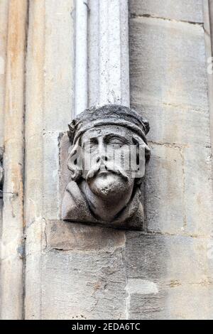 Scultura di una testa a destra del Corpus Clock (Grasshopper clock) nella facciata del Corpus Christi College, Università di Cambridge, Regno Unito Foto Stock