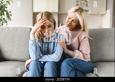 Preoccupata madre matura console sua figlia adulta, aiutando con il problema e la depressione, la cura lei, empatia, ha espresso il sostegno materno. Sostegno di una persona cara Foto Stock