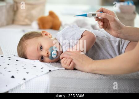 Mamma controllo neonato la temperatura con un termometro a infrarossi Foto  stock - Alamy