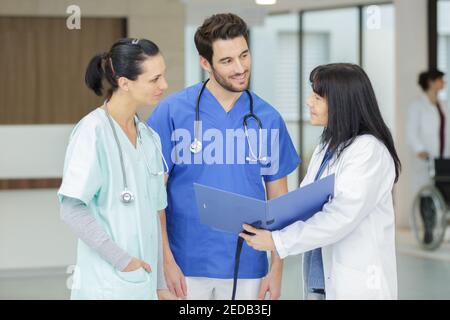 medico femminile che mostra qualcosa alla sua squadra medica Foto Stock