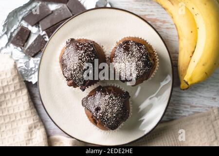Appartamento con vista dall'alto adagato su tortine di muffin al cioccolato con banana sul tavolo Foto Stock