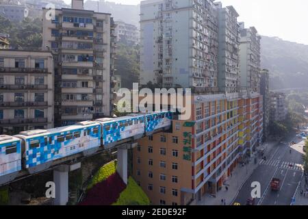 Vista aerea del treno della metropolitana alla stazione di Liziba a Chongqing, Cina, passando attraverso l'edificio Foto Stock