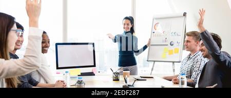 Giovane donna d'affari asiatica casual leader chiedendo parere nella riunione mentre facendo una presentazione, sfondo panoramico banner Foto Stock