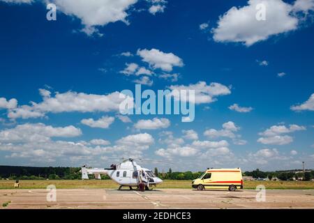 Un elicottero e un'ambulanza sono sulla pista. Concetto di trasporto per il personale medico. Foto Stock