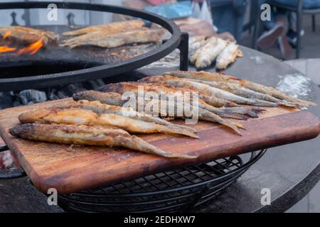 Pesce europeo puzzato croccante su tagliere di legno a. festival del cibo Foto Stock