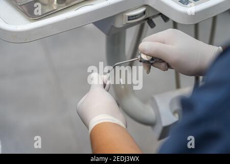 Primo piano foto di stomatologo che indossa guanti e che usa il professionista strumenti dentali in clinica Foto Stock