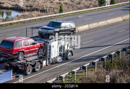 Carro di perforazione grande per trasporto di auto bianche di grado industriale per trasporto di semi-camion vetture incrociate sul semirimorchio modulare idraulico a due livelli correre sullo straig Foto Stock