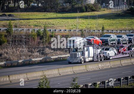 Carro di perforazione grande per trasporto di auto bianche di grado industriale per trasporto di semi-camion vetture incrociate sul semirimorchio modulare idraulico a due livelli correre sullo straig Foto Stock