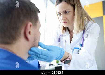 Donne medico palpating pazienti linfonodi submandibolari Foto Stock