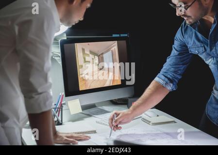 Architetto asiatico o team di interior designer che soggiornano fino a tarda notte in ufficio discutere progetto di progettazione della sala al tavolo riunioni Foto Stock