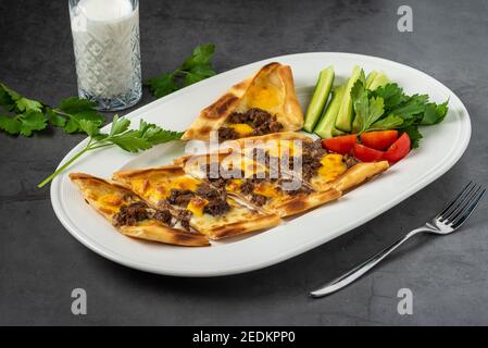 Pita ​​cubed di carne affettato con latticello e insalata su tavola di pietra. Foto Stock