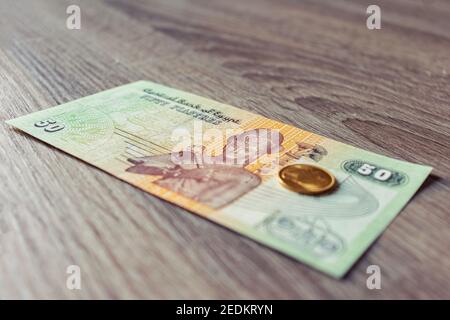 Primo piano della valuta egiziana (banconota da 50 piastres) e 5 qirsh moneta Foto Stock
