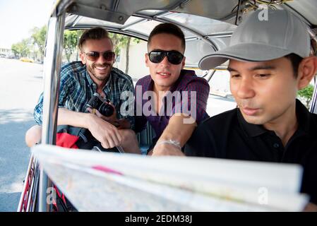 I turisti parlano con l'autista che chiede la posizione durante il viaggio Taxi locale Tuk Tuk a Bangkok Thailandia Foto Stock