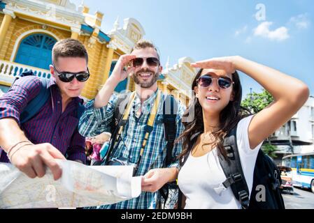 Gruppo di amici turisti zaino in spalla in cerca di direzione durante il viaggio A Bangkok in Thailandia durante le vacanze estive Foto Stock