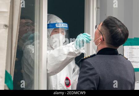 Test COVID-19, 14 febbraio 2021 : UN'infermiera preleva campioni da un cadetto della Korea Military Academy durante un test gratuito COVID-19 presso una clinica di improvvisazione a Seoul, Corea del Sud. La Corea del Sud inizierà le sue prime inoculazioni contro il COVID-19 il 26 febbraio con il vaccino COVID-19 sviluppato dal gigante farmaceutico britannico-svedese e dall'Università di Oxford, AstraZeneca. Credit: Lee Jae-Won/AFLO/Alamy Live News Foto Stock