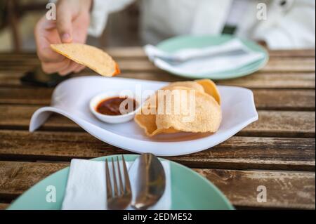 Donna che ha antipasto di cracker di gamberi thailandesi prima di pasto nel Ristorante di cucina thailandese Foto Stock