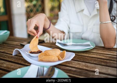 Donna che ha antipasto di cracker di gamberi thailandesi prima di pasto nel Ristorante di cucina thailandese Foto Stock